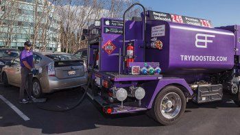 La empresa Booster Fuels suministra combustibles con sus exclusivos camiones de color púrpura para llenar los tanques de los autos mientras sus dueños están trabajando.