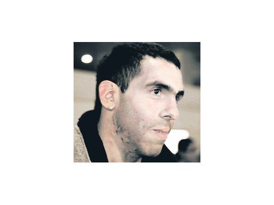 El rostro de Carlos Tevez al arribar al Aeropuerto Internacional de Ezeiza. «El Apache» seguramente será penado por viajar sin permiso del City.