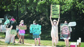 DESCONTENTO. Manifestantes adversos a Donald Trump se expresaron el fin de semana frente al complejo de golf de Virginia al que el presidente acudió a jugar.