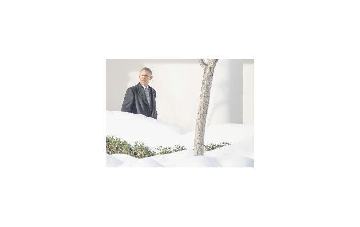 El presidente Barack Obama camina por uno de los pasillos externos de la Casa Blanca, cuyos jardines han sido tapados por las fuertes nevadas del fin de semana.