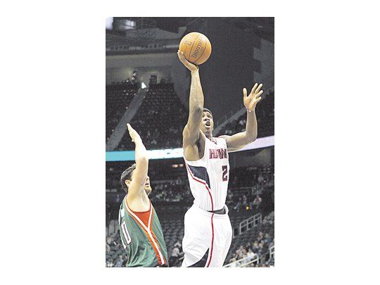 Joe Johnson se eleva y encesta ante la marca de Carlos Delfino. El argentino marcó 13 puntos en la derrota de los Bucks.