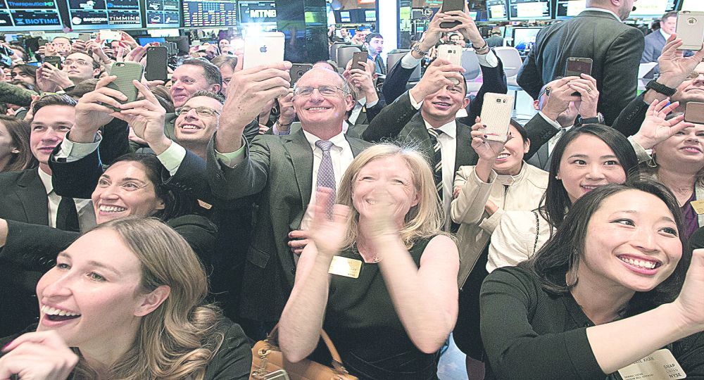 furor y millones. Festejan ayer en el NYSE John Spiegel y Melissa Ann Thomas (en el centro) los afortunados padres del CEO de Snap, Evan Spiegel. La valuación en u$s34.000 M de esta joven empresa creada por dos estudiantes universitarios dejó bien atrás a otras compañías, no sólo las locales.