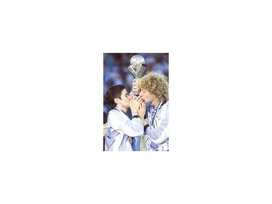 Javier Saviola y Fabricio Coloccini besan la copa.