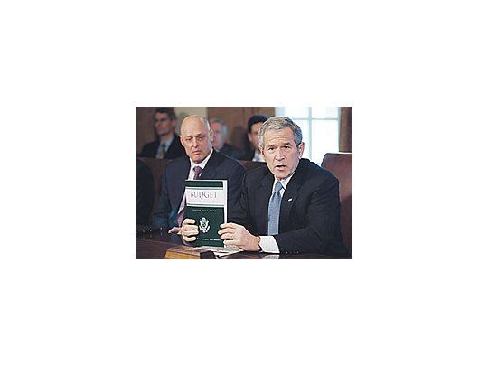 El presidente George W. Bush presenta el presupuesto durante una reunión con su gabinete. El secretario del Tesoro, Henry Mc. Paulson, escucha atento.