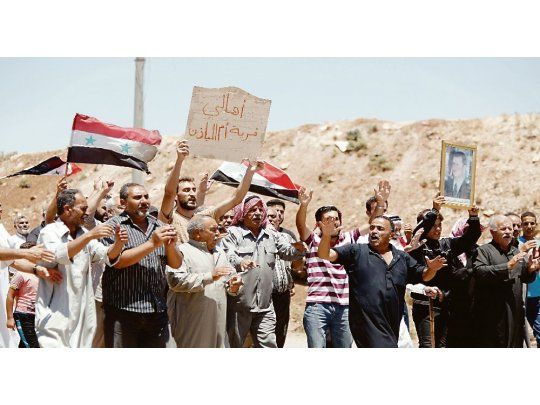 RECIBIDA. Los soldados que izaron la bandera en el centro de la ciudad fueron recibidos con carteles y aplausos. En algunas localidades fueron rechazados y en su lugar se desplegaron soldados rusos.