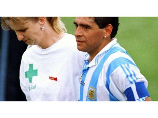 Maradona se retira del campo de juego de la mano de la enfermera para hacerse el control antidoping.