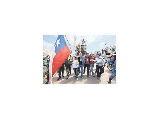 Familiares de los mineros atrapados en Copiapó y rescatistas acompañan el retiro de la máquina perforadora T130, la que logró abrir el túnel que permitirá el rescate. La operación será riesgosa, pero la expectativa es fuerte.