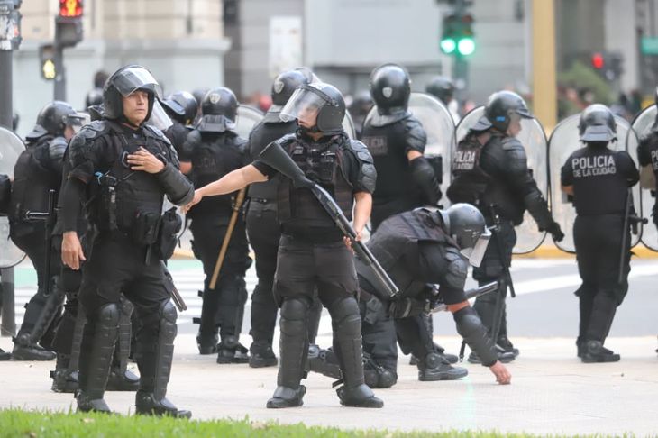 Efectivos de la Policía de la Ciudad recogen la vaina del disparo que acaban de ejecutar, durante la represión a la movilización el 12 de marzo. Efectivos de la Policía de la Ciudad recogen la vaina del disparo que acaban de ejecutar, durante la represión a la movilización el 12 de marzo.