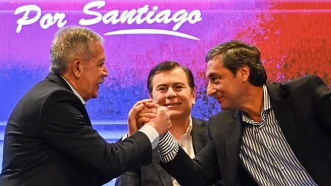 Elías Suárez y Carlos Silva Neder se estrechan la mano y en el medio, Gerardo Zamora, el gobernador saliente y actual senador nacional.