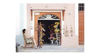 Una mujer espera clientes en la puerta de su casa en La Habana, donde vende muebles y artículos de decoración. La expansión del sector privado es la gran apuesta del régimen de Raúl Castro para compensar el desempleo que generará la reforma del Estado.