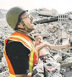 A rescuer removes the body of a child from the ruins in Qana, Lebanon. The dramatic images caused by the Israeli bombing could accelerate the search for a ceasefire in the region. A rescuer removes the body of a child from the ruins in Qana, Lebanon. The dramatic images caused by the Israeli bombing could accelerate the search for a ceasefire in the region.