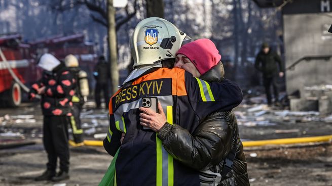 Un rescatista consuela a una mujer tras un ataque ruso en Kiev.