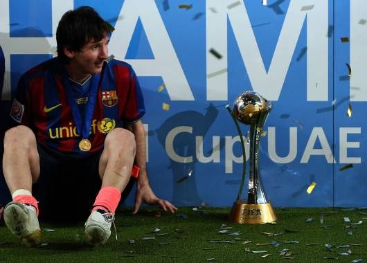 Messi mira la copa mientras los papelitos caen y el festejo se desata.