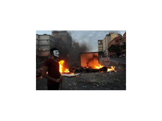 Un manifestante enmascarado en una calle que sufrió las corridas de la policía.