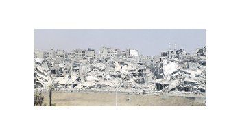 Imagen de edificios dañados y escombros en un barrio de Homs, uno de los enclaves más castigados por el conflicto.