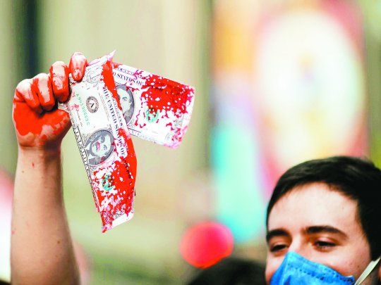 DINERO MANCHADO. Un manifestante antibolsonarista se mostró en una marcha realizada a principios de mes en San Pablo con dólares falsos en los que aparece la cara del presidente de Brasil y manchas que simulan sangre. El Vacunagate le pega de lleno al Gobierno.