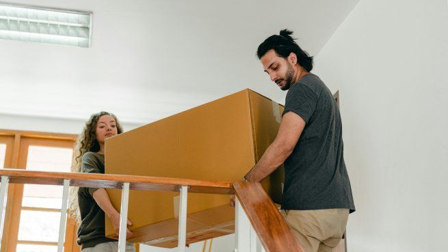 Una pareja traslada cajas en su mudanza. En Argentina, cambiar de casa sigue siendo una excepción marcada por barreras económicas y falta de financiamiento