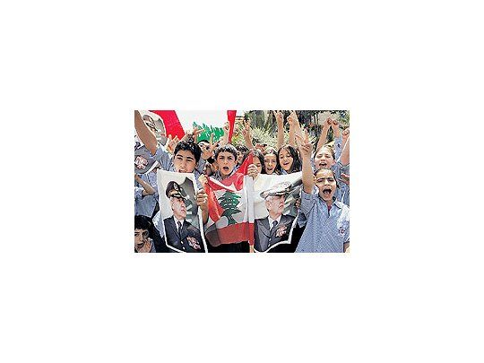 Un jubiloso grupo de escolares exhibe ante los fotógrafos banderas libanesas y fotos del próximo presidente del país, el general Michel Suleiman. Todo Líbano respiró aliviado tras conocerse el acuerdo que aleja el fantasma de una nueva guerra civil.
