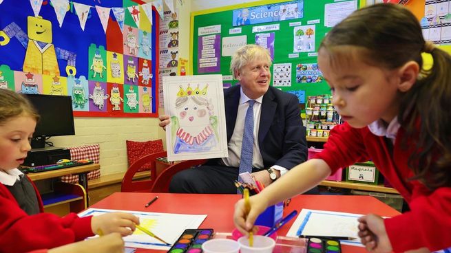 El primer ministro de Reino Unido, Boris Johnson, sostiene un dibujo de la reina Isabel II.