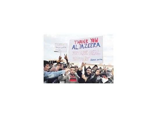 Manifestantes que celebran en la ciudad de Tobruk portan un cartel agradeciendo a la cadena qatarí Al Yazira. En Bengasi, epicentro de la revuelta, temían anoche bombardeos. Muamar Gadafi convocó ayer por TV a «capturar a las ratas».