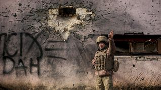 Un soldado ucraniano revisa los daños causados por una granada en un edificio de Lugansk.