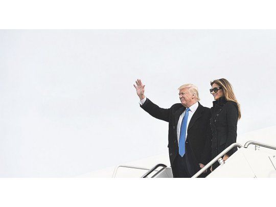 ENCUENTRO CON LA HISTORIA. Donald Trump y su esposa, Melania, ayer al llegar a la base aérea de Andrews, en Maryland. Hoy jurará como presidente cerca de allí, en Washington.