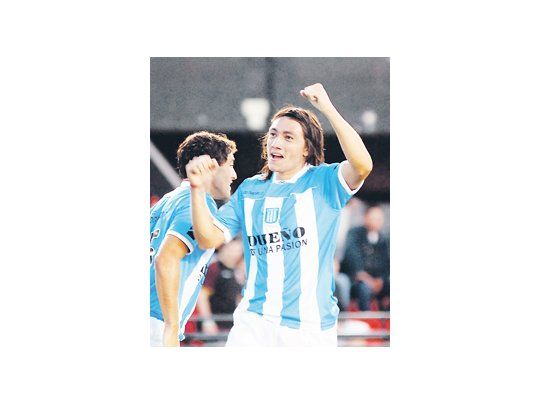Pablo Lugüercio festeja su tanto levantando los brazos. Racing goleó a Colón en el Cementerio de los Elefantes y es el único líder del Clausura.