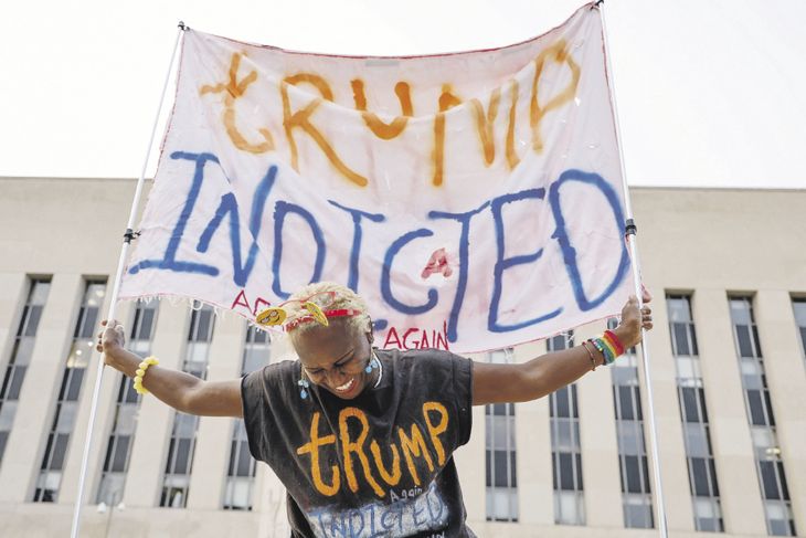 ESPERA. Una manifestante sostiene una pancarta frente al tribunal federal donde se espera que el expresidente de EE.UU Donald Trump responda a los cargos.