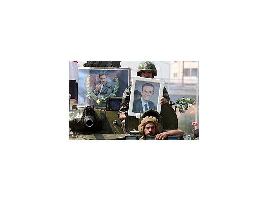 Soldados del régimen siria exponen retratos del presidente Bashar al Asad.