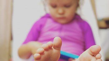 Una niña juega con el teléfono.