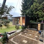 Montaje de módulos industrializados en un terreno en pendiente, con grúa y bases preparadas para el armado de la vivienda Montaje de módulos industrializados en un terreno en pendiente, con grúa y bases preparadas para el armado de la vivienda