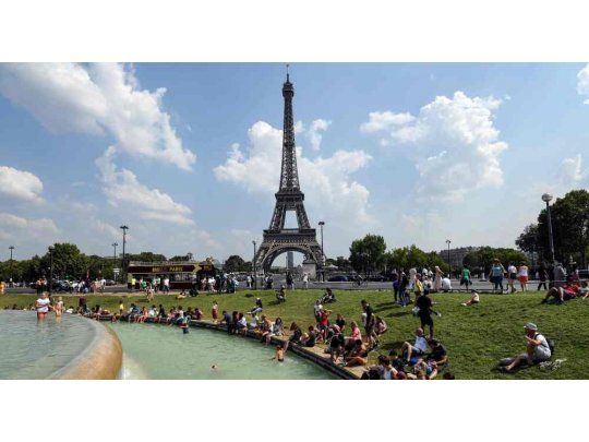 En París, ciudadanos se acercaron a la fuente a metros de la Torre Eiffel para mitigar el calor.