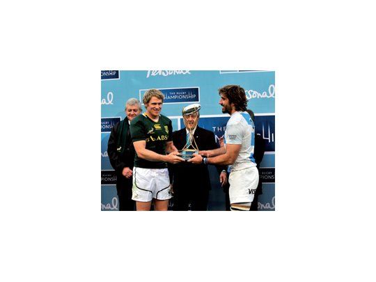 Copa compartida . El capitán sudafricano y su similar argentino reciben el trofeo de manos de Luis Castillo.