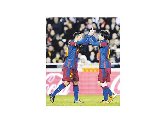 Lionel Messi va a abrazarse con Adriano festejando su gol. Barcelona le ganó 1 a 0 a Valencia y va rumbo al título.