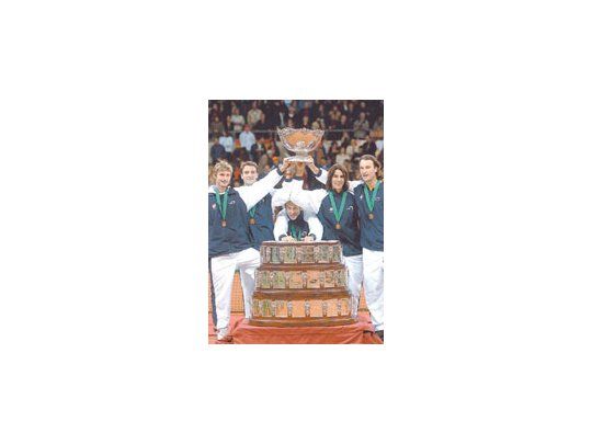 Juan Carlos Ferrero, Tommy Robredo, Rafael Nadal y Carlos Moyá, junto con el capitán del equipo español, Jordi Arrese, rodean el trofeo, tras ganar la Copa Davis.