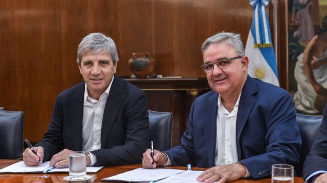 Luis Caputo y el catamarqueño Raúl Jalil, firmando la adhesión de la provincia al Régimen.