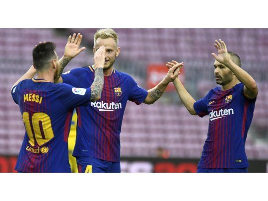 Messi se saluda con Rakitic e Iniesta luego de uno de sus goles.