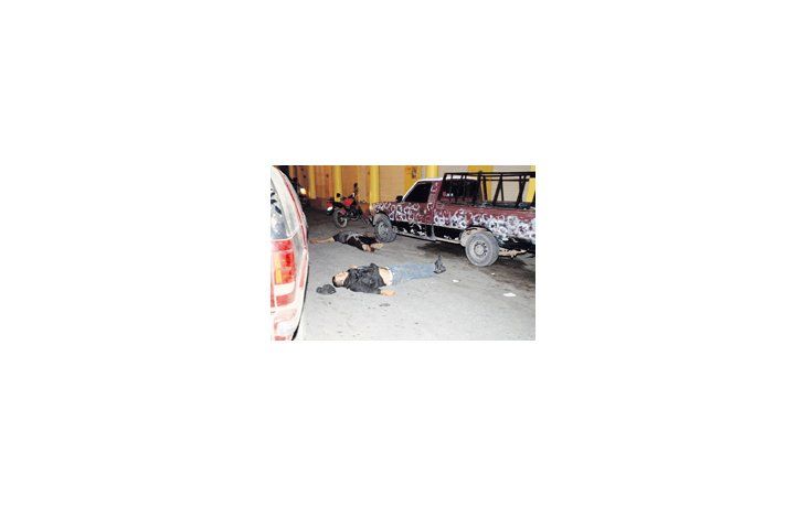 Dos hombres yacen muertos en una calle de la localidad mexicana de Tecalitlan. La creciente violencia ligada al narcotráfico se extiende hacia todo el territorio de ese país.