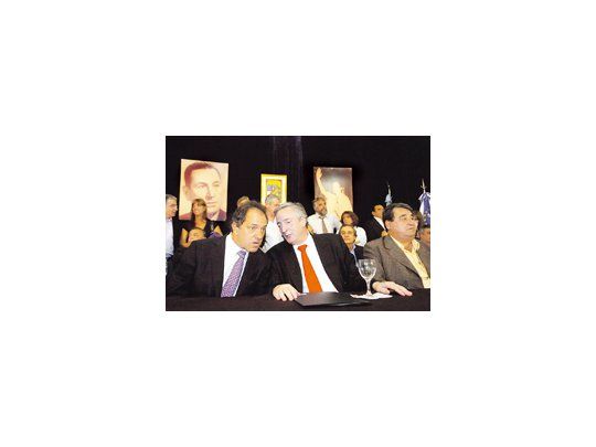 Néstor Kirchner, flanqueado por Daniel Scioli y Hugo Curto, durante un encuentro con intendentes y legisladores del PJ donde pidió apoyo a la Ley de Radiodifusión.