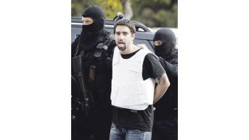 Un detenido por la ola de envíos de paquetes bomba a embajadas en Atenas es trasladado por la Policía. Uno de los despachos llegó a la Jefatura de Gobierno en Alemania.