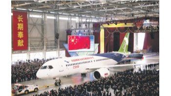 El C919 salió de un gigantesco hangar decorado con los colores de la bandera china ayer. Con el proyecto se busca competir con los dos grandes del sector.