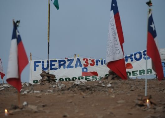 33 banderas representando cada uno de los trabajadores atrapados a 700 metros bajo tierra.