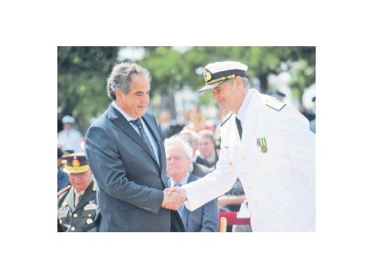 El ministro Julio Martínez estrecha la mano del nuevo titular de la Armada, Marcelo Srur, durante el acto en el Edificio Libertad. De fondo, el presidente provisional del Senado, Federico Pinedo, y autoridades militares.