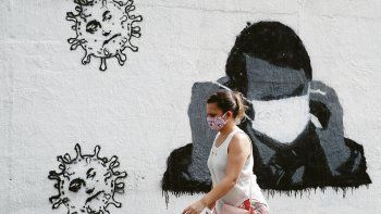 ÍCONO. La conocida imagen de Jair Bolsonaro luchando para colocarse con un tapaboca ya es graffiti en los muros de Río de Janeiro.
