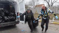 Servicios funerarios recuperan cuerpos de las calles de Bucha.