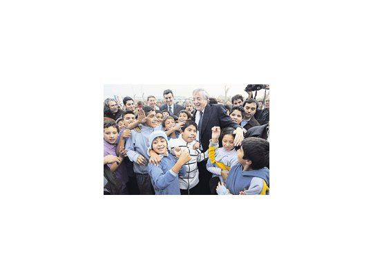 Néstor Kirchner, ayer en La Matanza, rodeado de chicos entre los que asoman el intendente Fernando Espinoza y el ministro Florencio Randazzo.