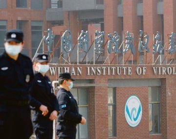 SUPERVIGILADO. Efectivos de seguridad chinos montan guardia ante el Instituto de Virología de Wuhan. Esa ciudad fue el epicentro del inicio de la pandemia y persisten las sospechas internacionales de que esta pudo originarse a raíz de un experimento que se salió de control.