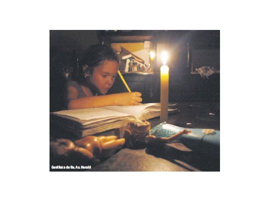 Una niña venezolana hace su tarea a la luz de una vela. El racionamiento de energía se suma a una crisis que es a la vez económica y política, y puede afectar más la decaída imagen de Nicolás Maduro ante el referendo revocatorio que se realizará este año.