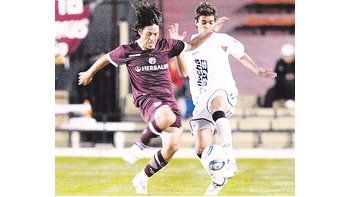 Mauro Camoranesi lucha con Mario Bellone. El veterano volante fue clave en el triunfo de Lanús en Santa Fe.