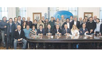 ámbito.com | Máximo Kirchner, casi fuera de cuadro, abre la hilera, de izquierda a derecha, de los intendentes, legisladores y dirigentes que ayer se encontraron en el Congreso para unificar una postura y un plan para ir contra los “tarifazos”, tema que reunió a las d
